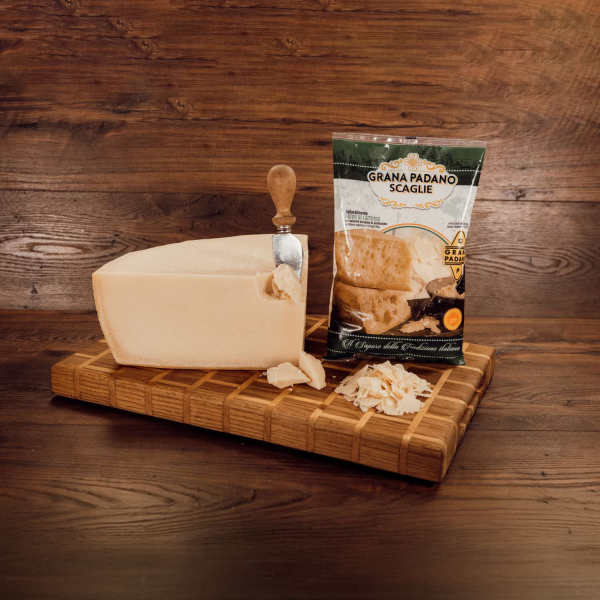 Busta contenente scaglie di Grana Padano DOP, con pezzi di formaggio di forma irregolare e colore paglierino chiaro. Venduto da Orobica Food.