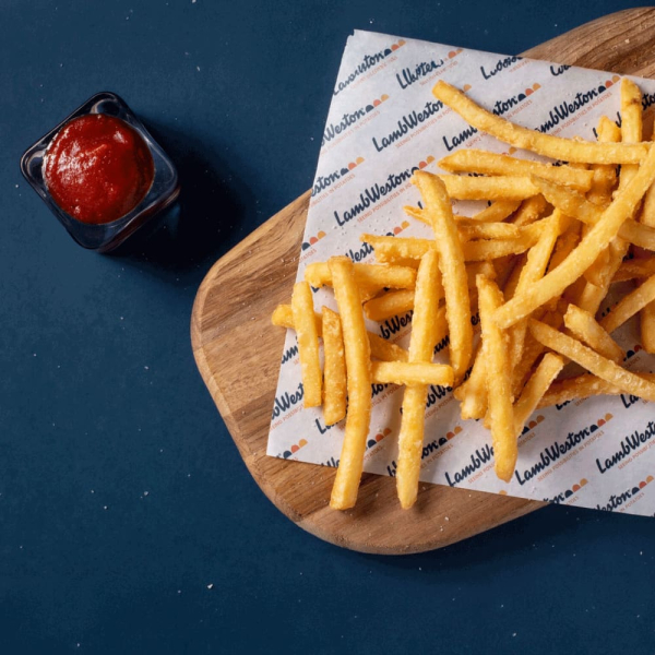 Patate a fiammifero crunchy mm.6x6, impiattate su un tagliere, accompagnate da una salsa rossa. Venduto da Orobica Food.